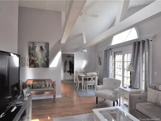 a living room with furniture wooden floor and a flat screen tv