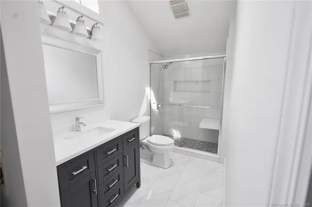 a bathroom with a double vanity sink toilet and shower