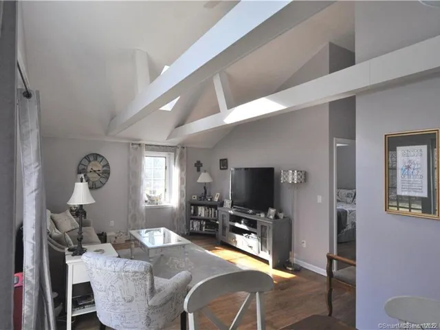 a living room with furniture a window and a flat screen tv