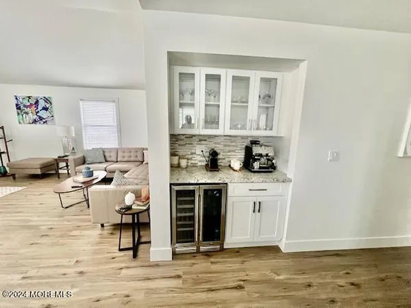 a kitchen with a stove and white cabinets with wooden floor