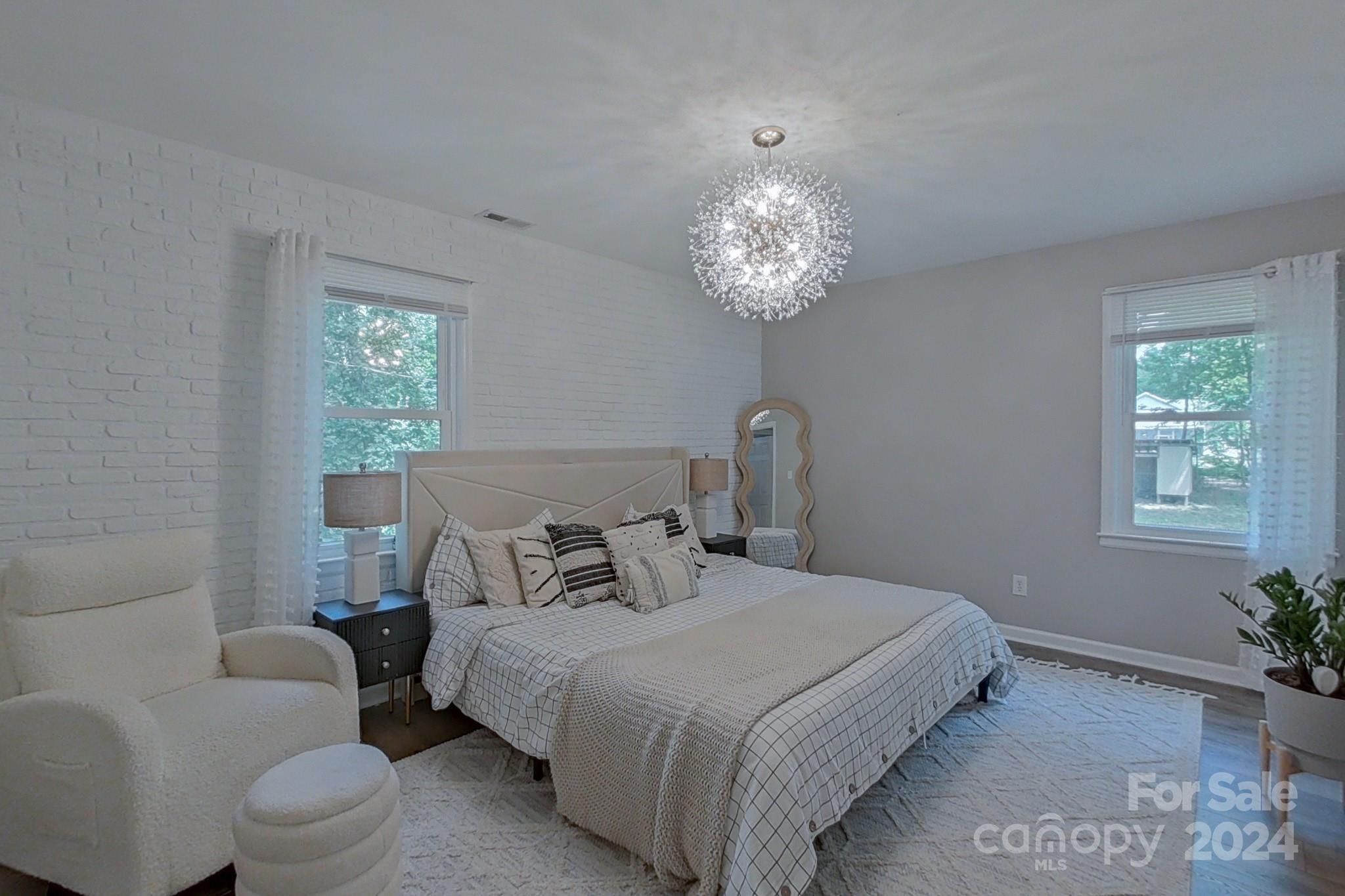 202 Smith Street Locust, NC 28097 - Photo 13 of 42 a bedroom with a bed and a chandelier