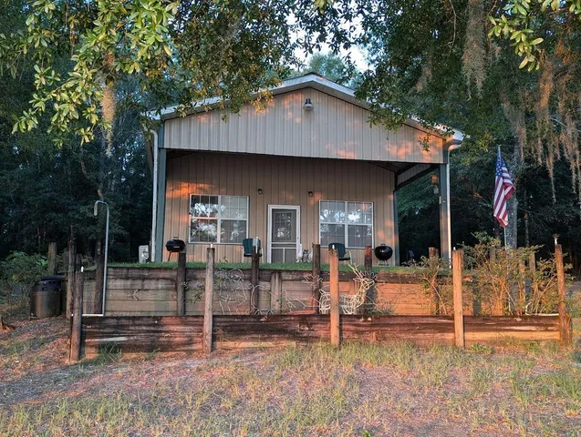 a view of a house with wooden fence and a large tree