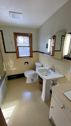 a bathroom with a sink a toilet and mirror