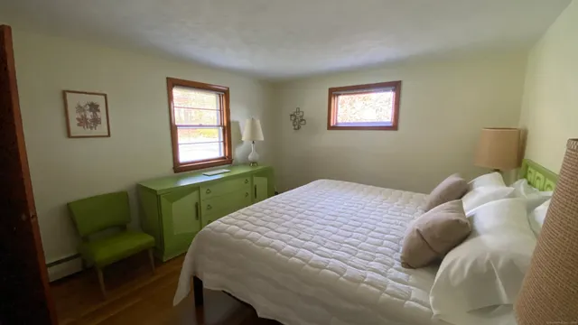 a bedroom with a bed table and window