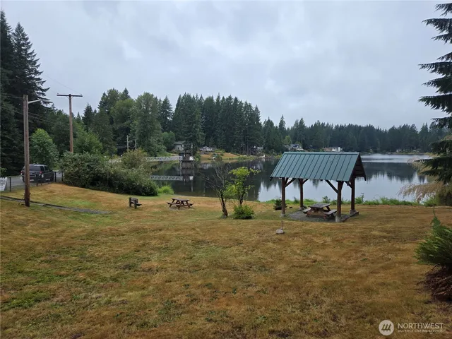 a backyard of a house with lots of green space and lake view