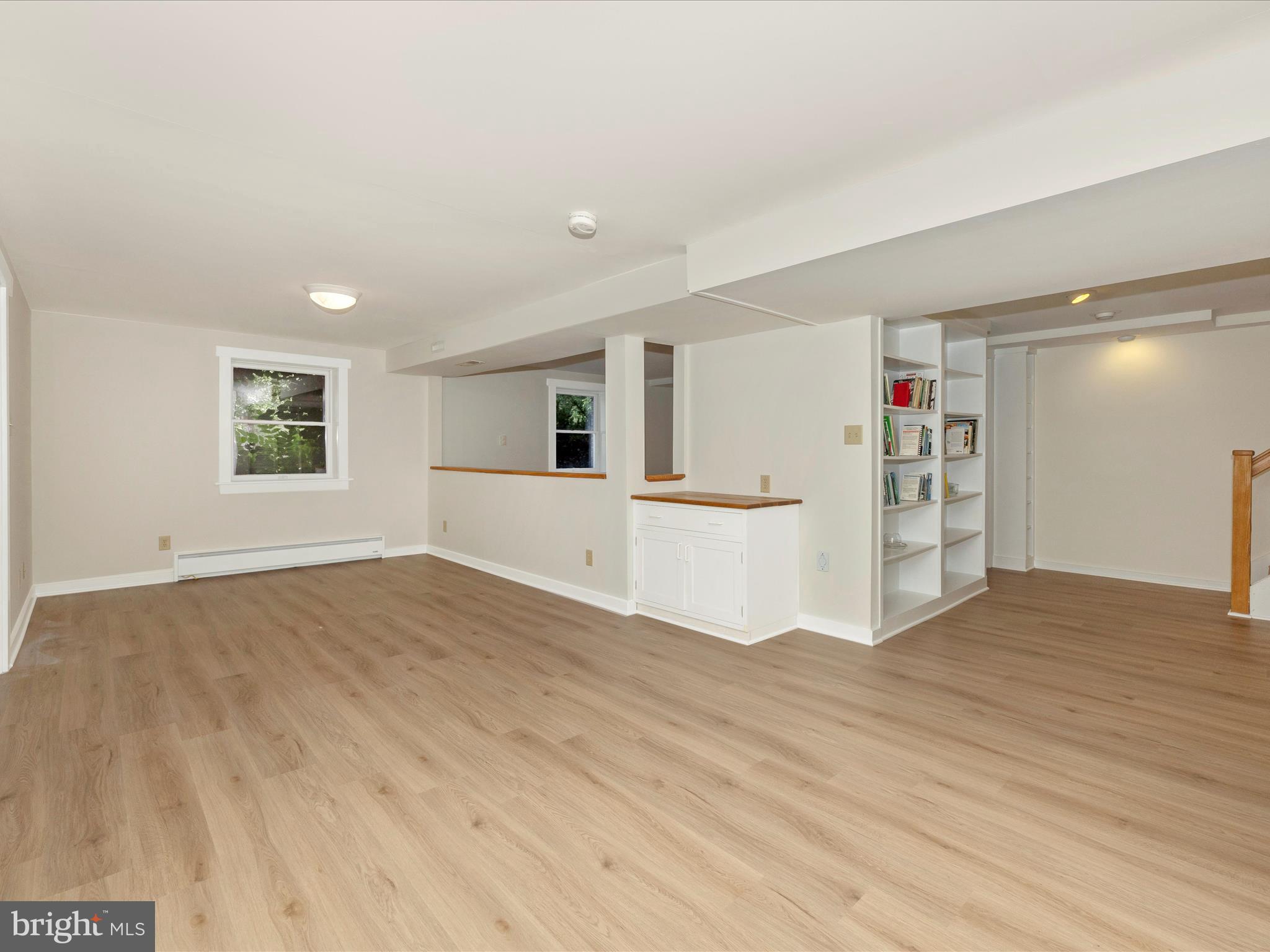 12436 Legore Road Keymar, MD 21757 - Photo 48 of 72 a view of empty room with wooden floor and kitchen