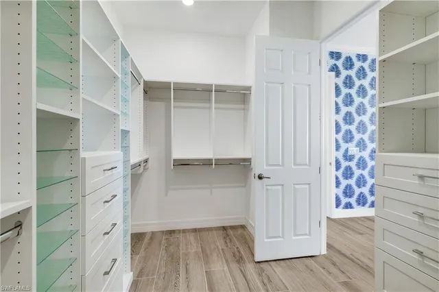a view of walk in closet with wooden floor