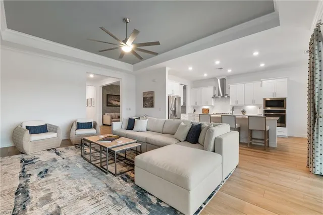 a living room with couches and kitchen view with wooden floor