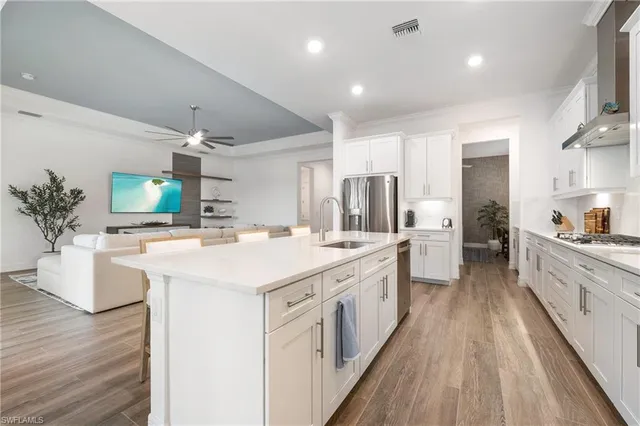a large kitchen with a lot of counter space and wooden floor