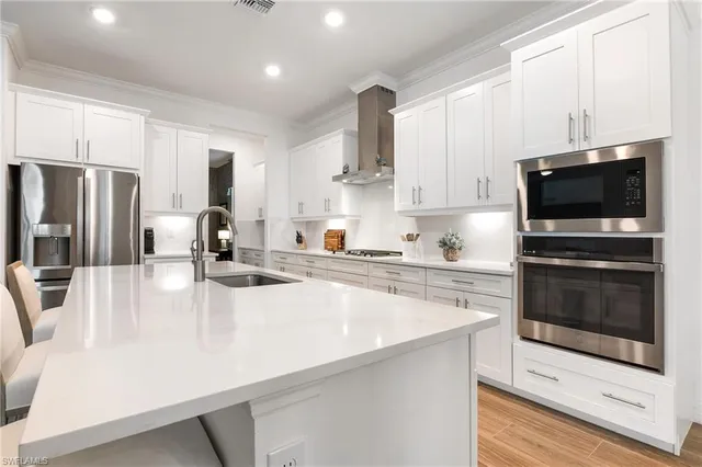 a kitchen with stainless steel appliances a stove a sink a microwave and cabinets