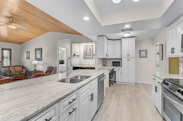 a kitchen with counter top space a sink stainless steel appliances and cabinets