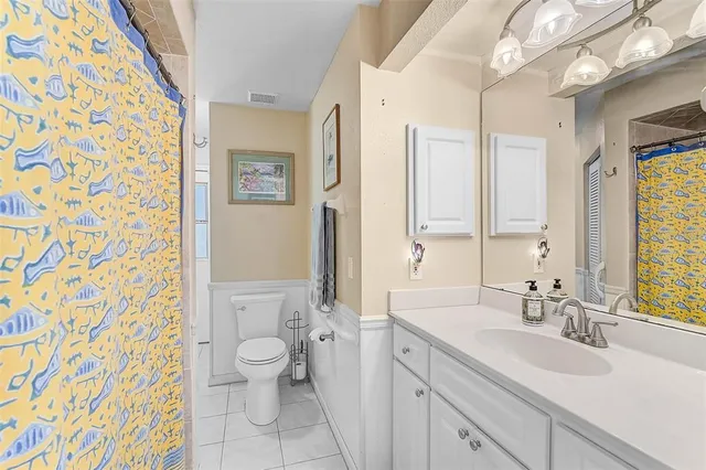 a spacious bathroom with a sink a toilet and a large mirror