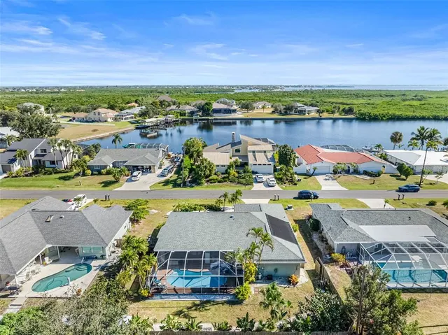 an aerial view of a house with a lake view and a mountain view in the back