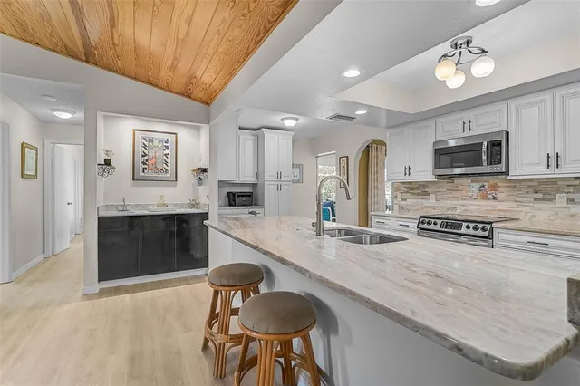 a large kitchen with stainless steel appliances granite countertop a stove and a sink