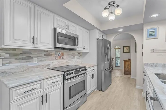 a kitchen with stainless steel appliances granite countertop a stove cabinets and refrigerator