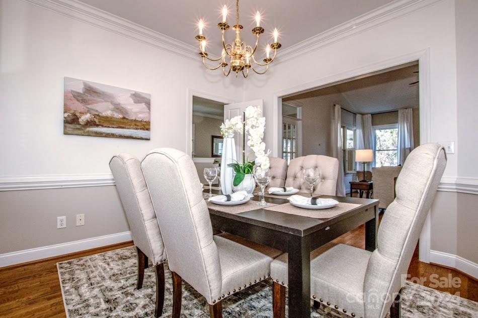218 North Kimberly Road Davidson, NC 28036 - Photo 11 of 44 a view of a dining room with furniture a chandelier and wooden floor