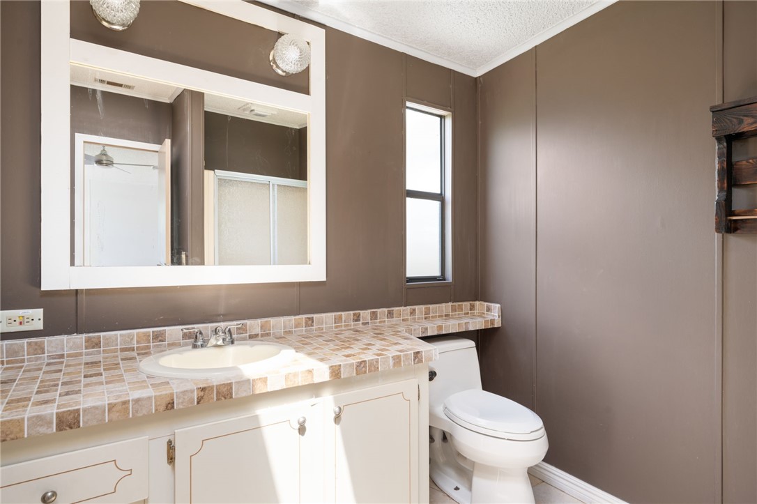 3836 13th Street Micco, FL 32976 - Photo 21 of 35 a bathroom with a granite countertop sink mirror vanity and toilet