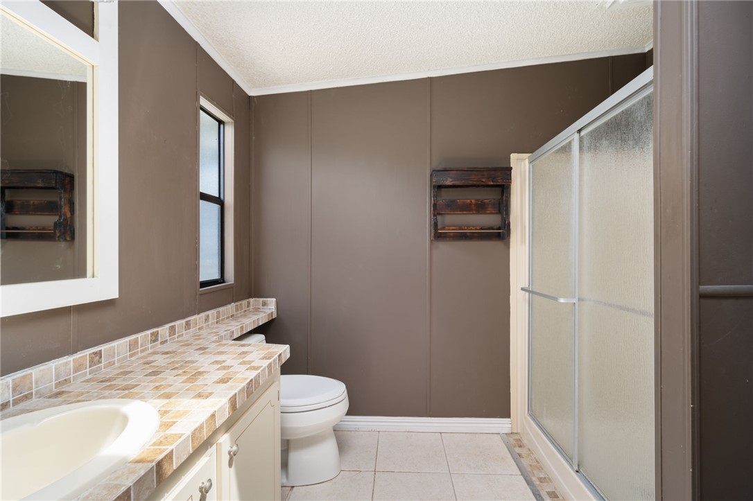 3836 13th Street Micco, FL 32976 - Photo 22 of 35 a bathroom with a granite countertop sink toilet and shower