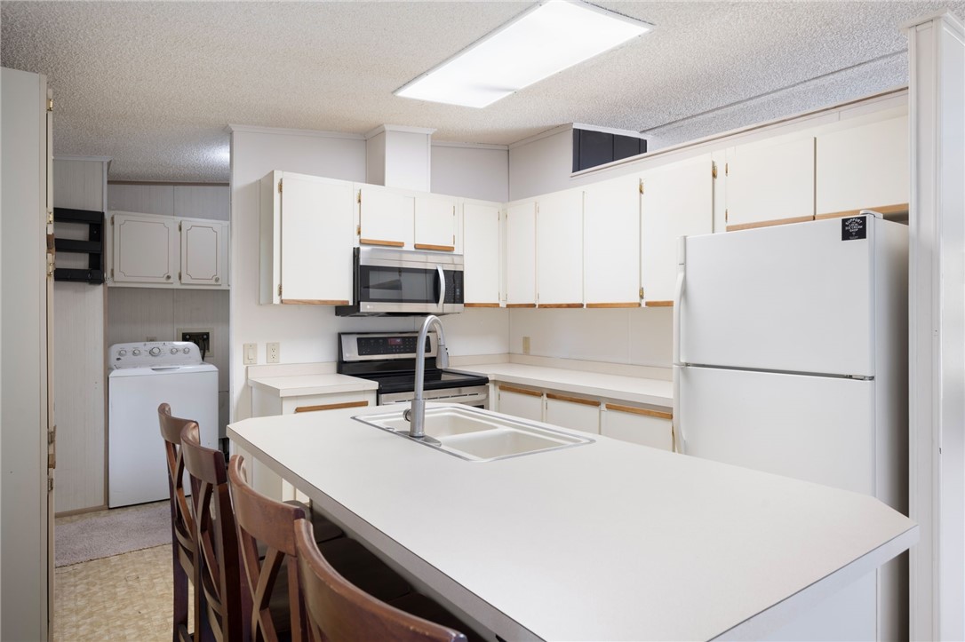 3836 13th Street Micco, FL 32976 - Photo 10 of 35 a kitchen with stainless steel appliances a refrigerator a stove a sink and white cabinets