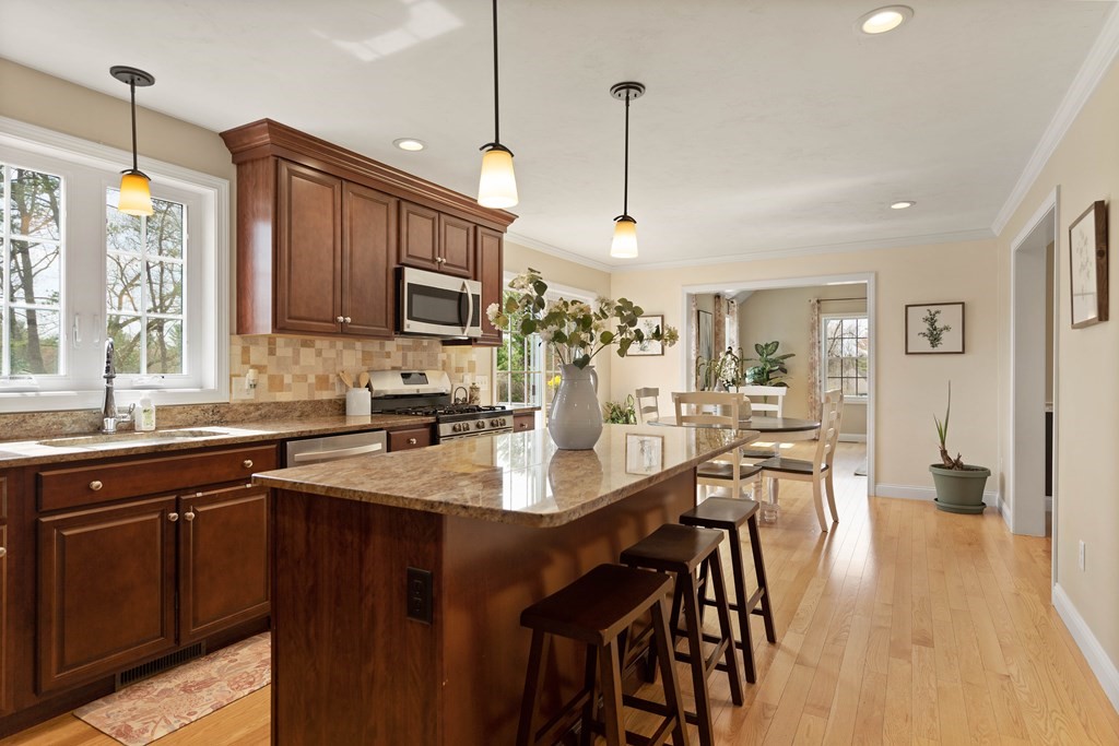 360 Richardson Road Dracut, MA 01826 - Photo 7 of 25 a kitchen with stainless steel appliances granite countertop a stove a sink dishwasher a refrigerator with a dining table and chairs