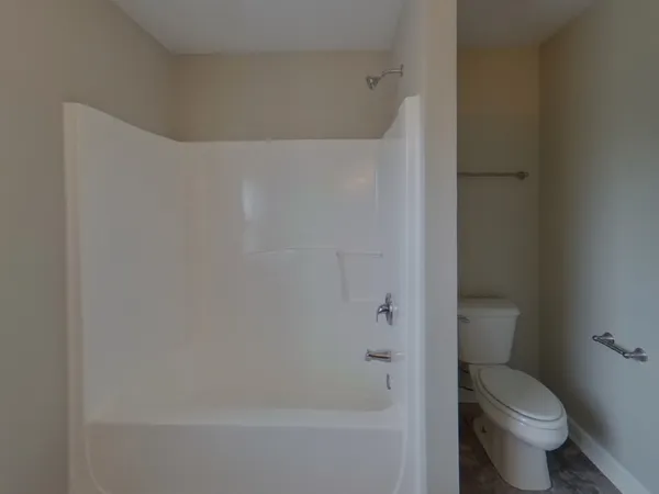 a bathroom with a toilet and a shower
