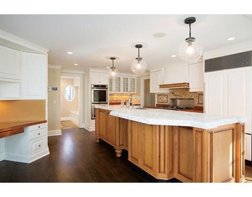 131 Laurel Road Brookline, MA 02467 - Photo 9 of 22 a kitchen with stainless steel appliances kitchen island granite countertop a stove a sink a refrigerator and white cabinets with wooden floor