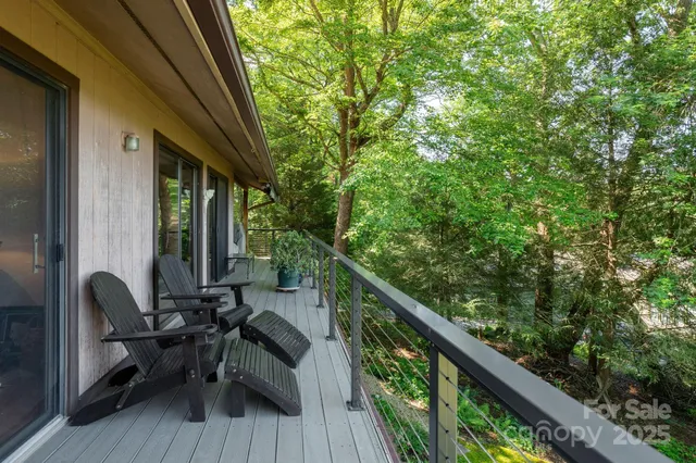 a view of a balcony with chairs and wooden floor