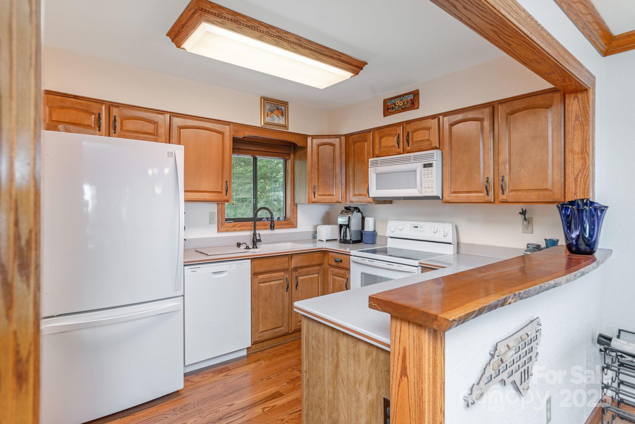 524 Three Mile Knob Road, Unit 3 Pisgah Forest, NC 28768 - Photo 20 of 33 a kitchen with stainless steel appliances a refrigerator sink and cabinets