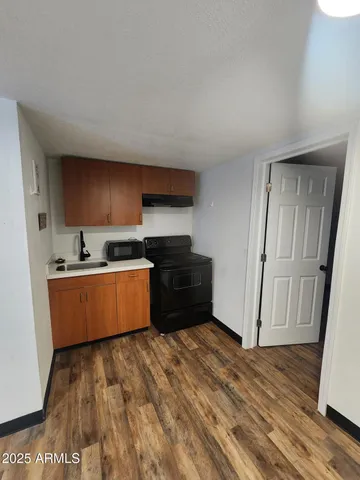 a kitchen with wooden floors and wooden cabinets