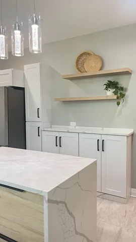 a view of a kitchen with a sink cabinet and a refrigerator