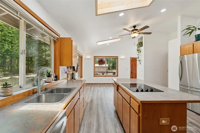 a living room with stainless steel appliances kitchen island furniture and a large window