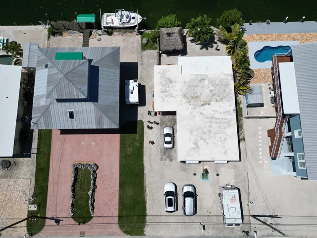 an aerial view of residential houses with outdoor space and parking