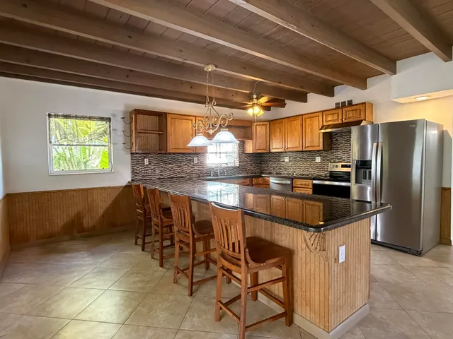 a kitchen with stainless steel appliances granite countertop a sink and a refrigerator