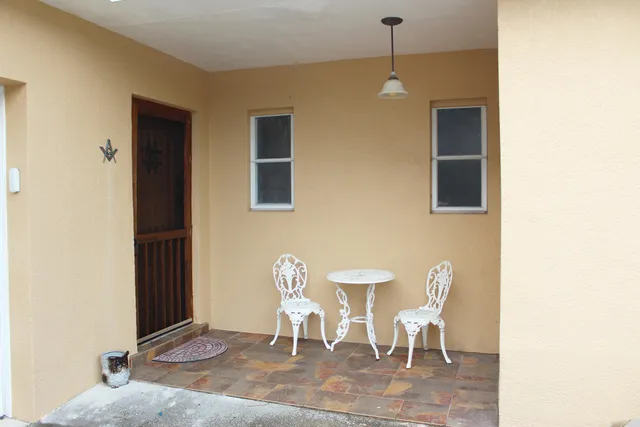 a living room with a table chairs and a window