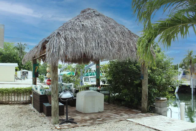 a backyard of a house with table and chairs potted plants
