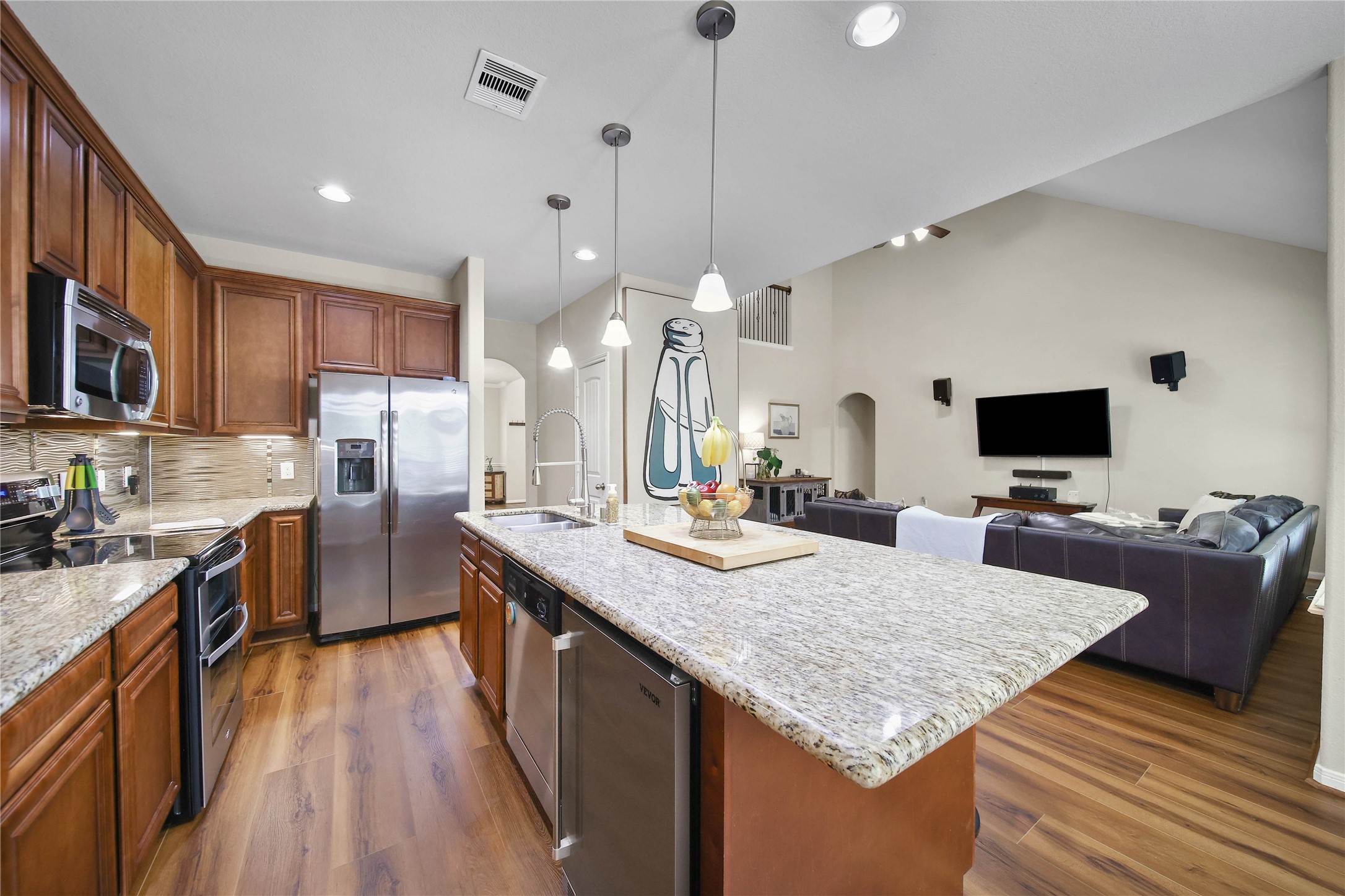 9223 Wapiti Trail Conroe, TX 77303 - Photo 19 of 45 a large kitchen with kitchen island a large island in the center a sink stainless steel appliances and cabinets