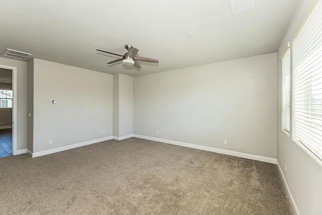 an empty room with a window and a fan