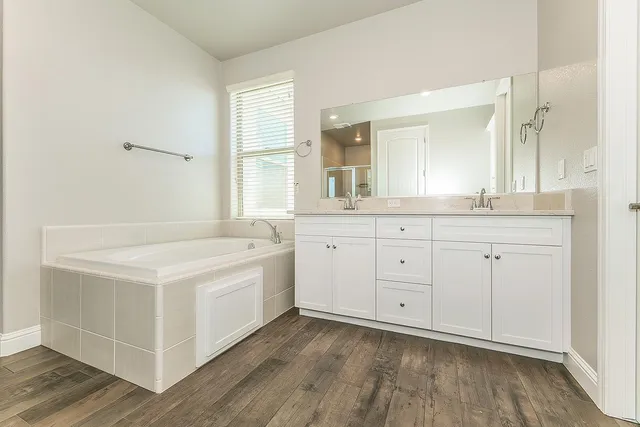 a spacious bathroom with a granite countertop sink and a mirror