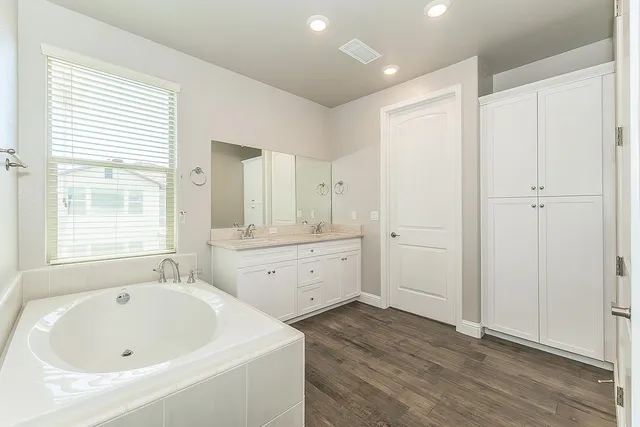 a bathroom with a tub sink and mirror