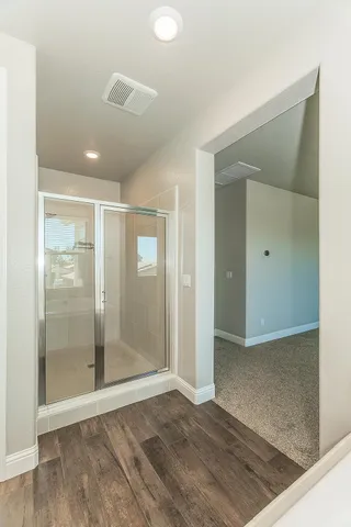 an empty room with wooden floor and mirror
