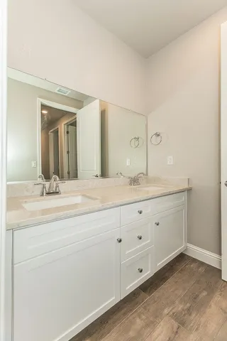 a bathroom with double sink and a mirror