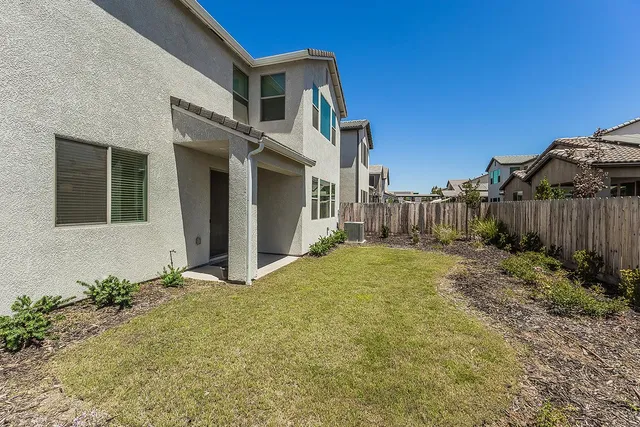 a view of a house with backyard and sitting area