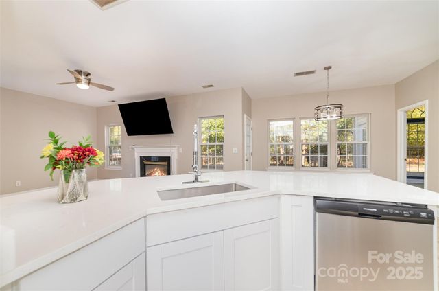 a kitchen with a sink and a flat screen tv