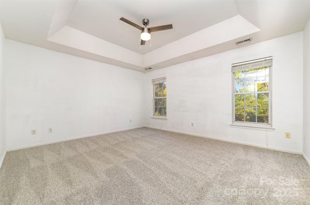 an empty room with ceiling fan and window