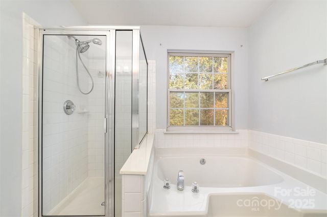 a bathroom with a tub shower and a window