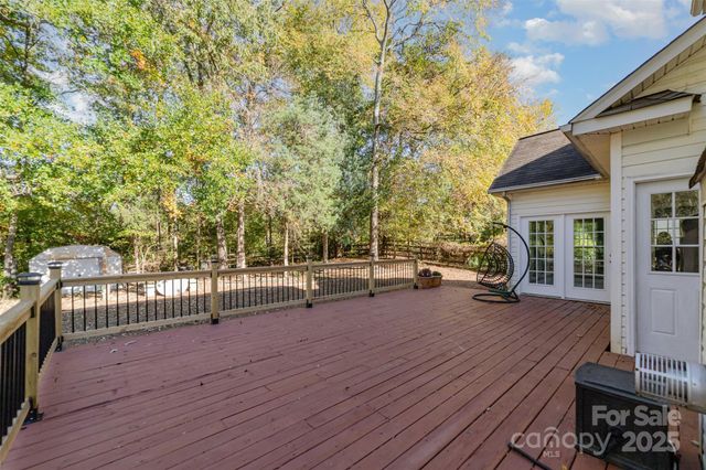 a view of a patio with table and chairs with wooden floor and fence