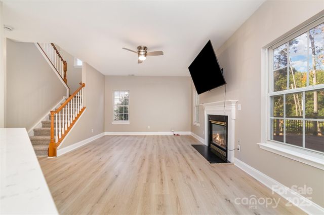 a view of empty room with fireplace and wooden floor
