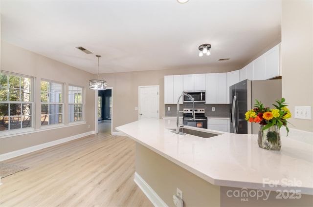 a kitchen with stainless steel appliances a sink refrigerator and microwave
