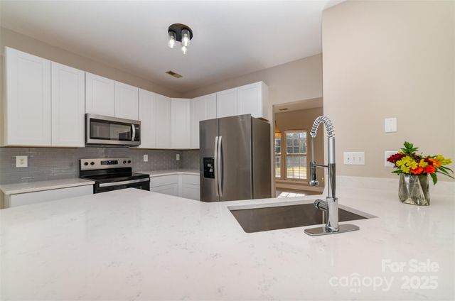 a kitchen with stainless steel appliances a refrigerator and a stove top oven