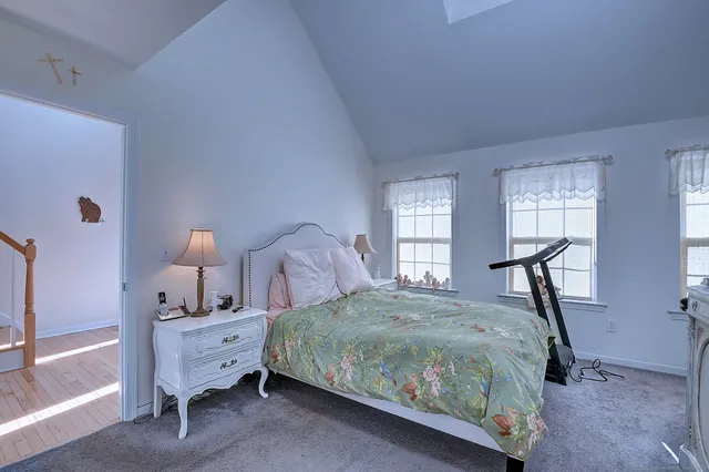 a bedroom with a bed and large windows
